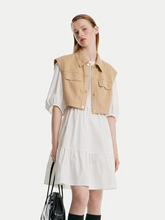 a lady in white a-line mini dress with camel vest